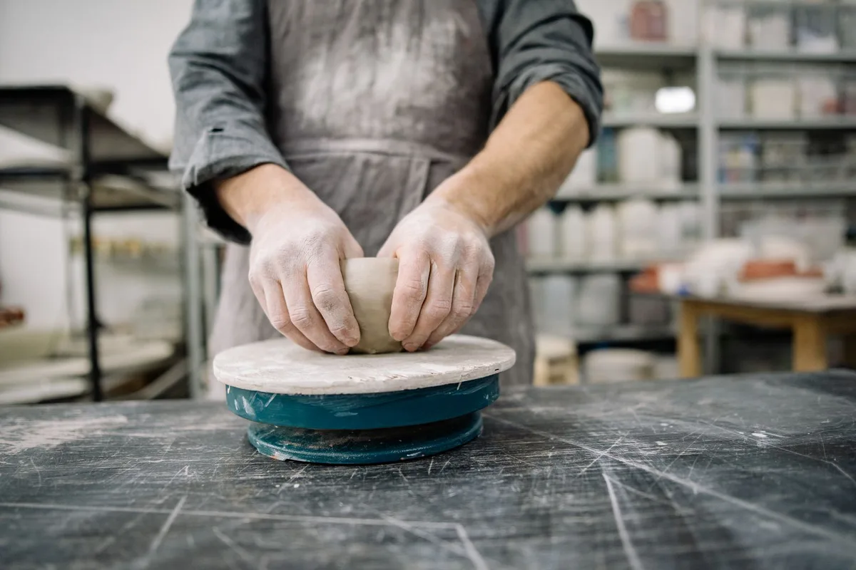 Potter shaping clay for an image to prompt tags example